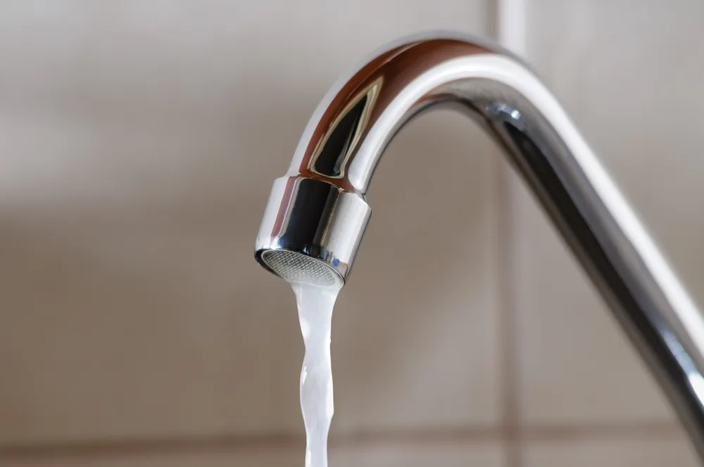 Leaky faucet dripping water into a sink